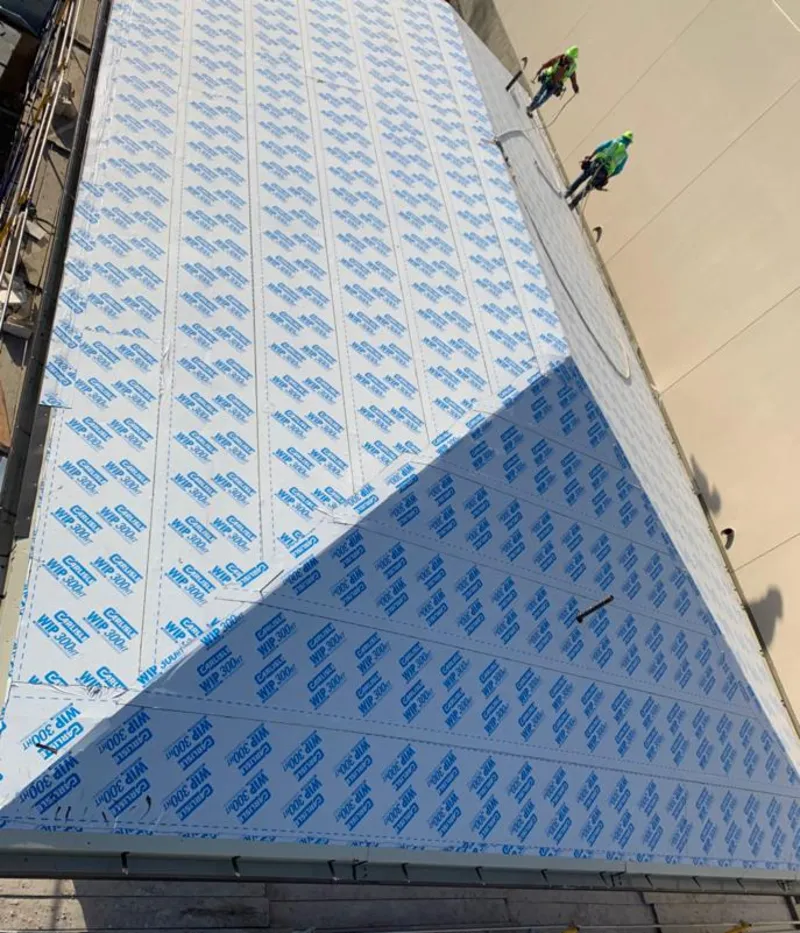 Professional roofers installing underlayment on a metal roof in Guttenberg